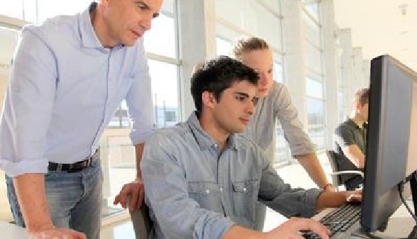 Junger Mann wird am Computer eingeschult